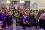 Large group socializing in front of a Liberty Specialty Markets poster at a risk conference