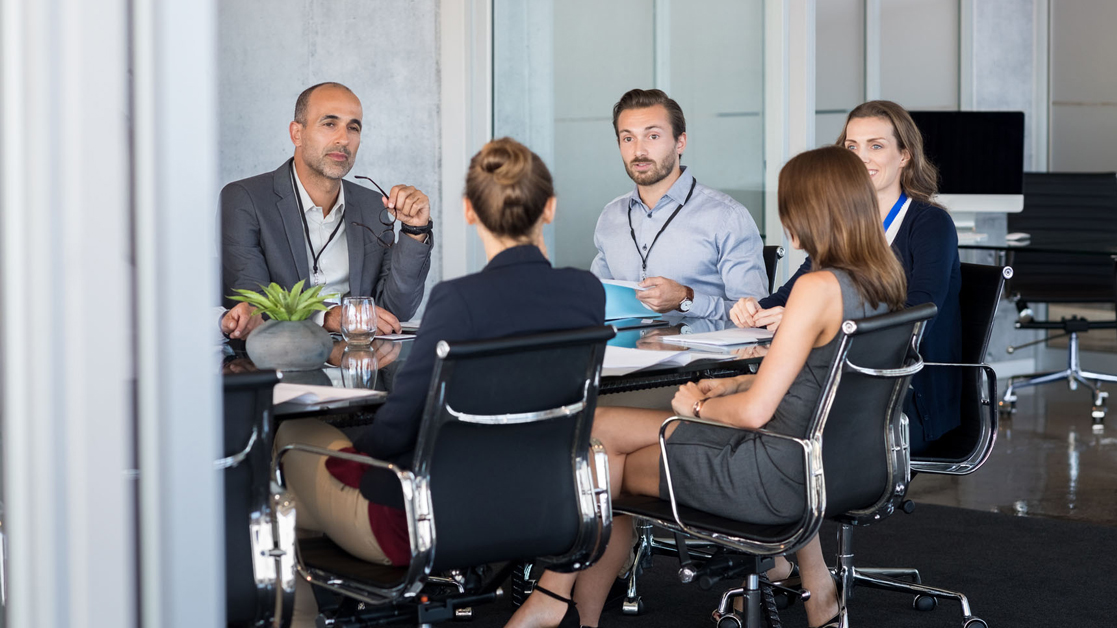 Group of business professionals sitting around a conference table working together