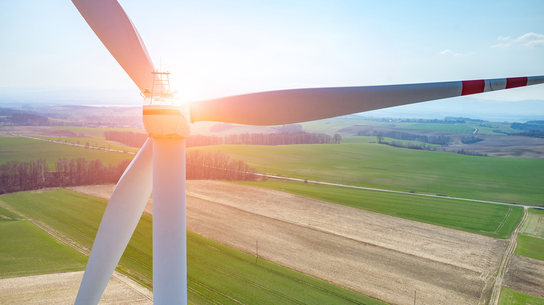 Wind turbine on a large field during sunset