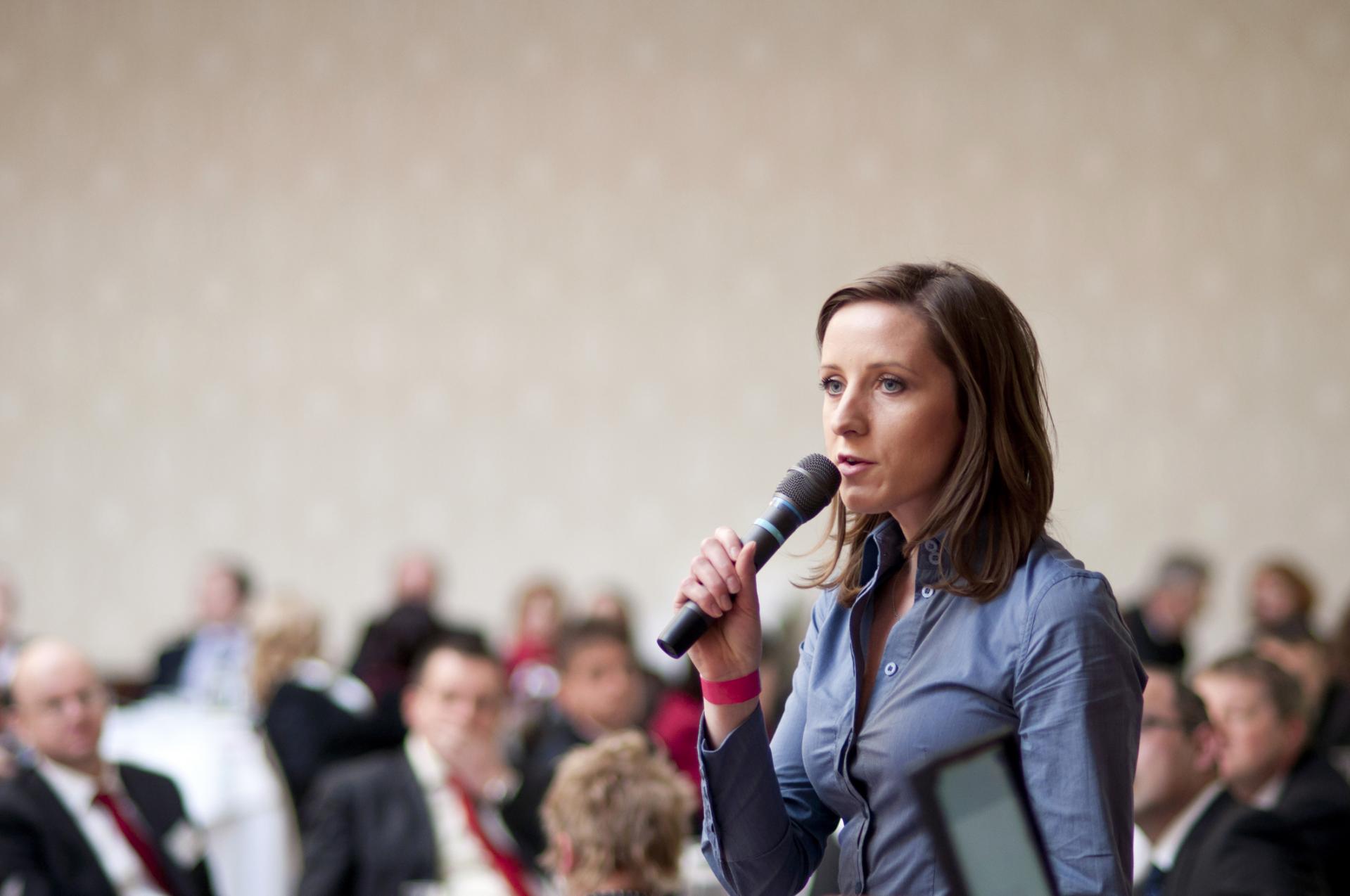 Women standing up speaking in microphone
