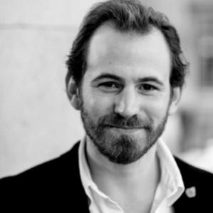 Black and white photo of bearded man in a suit