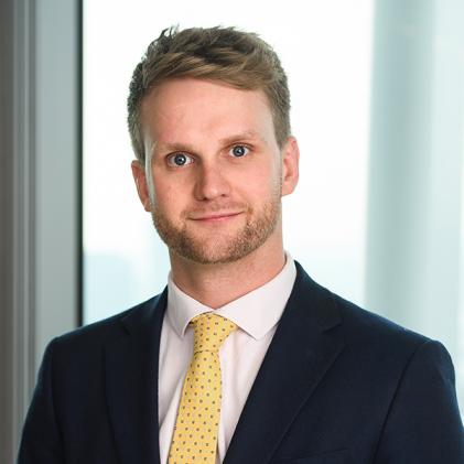 photo of man smiling, yellow tie, white shirt, black suit jacker