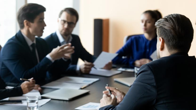 Employees and clents sitting at a table talking