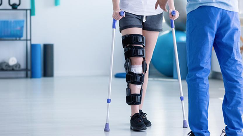 patient in knee brace and crutches