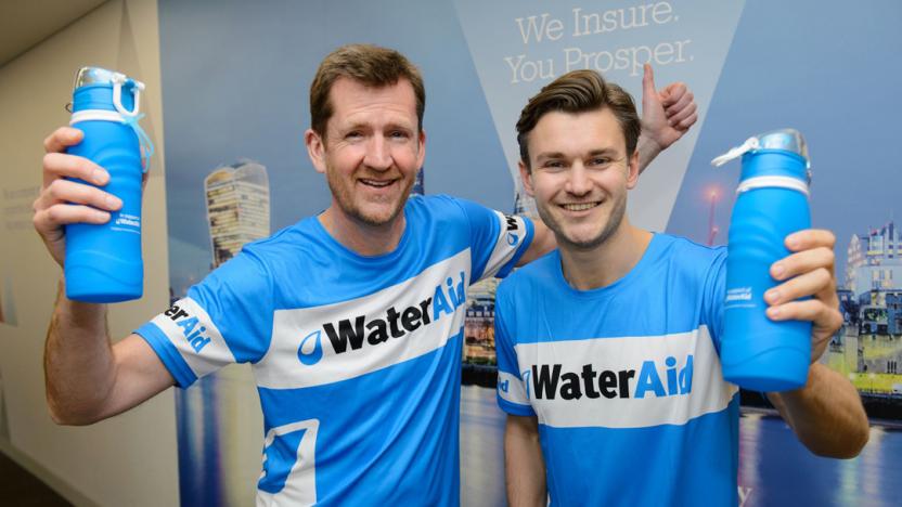Two people in blue tshirst holding water bottles