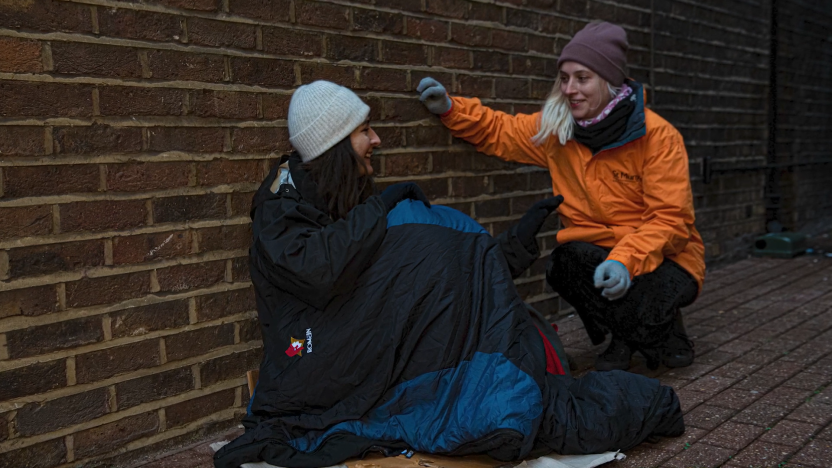 women talking to a homeless person