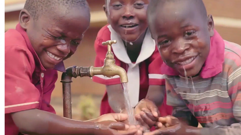Children smiling with water on their face