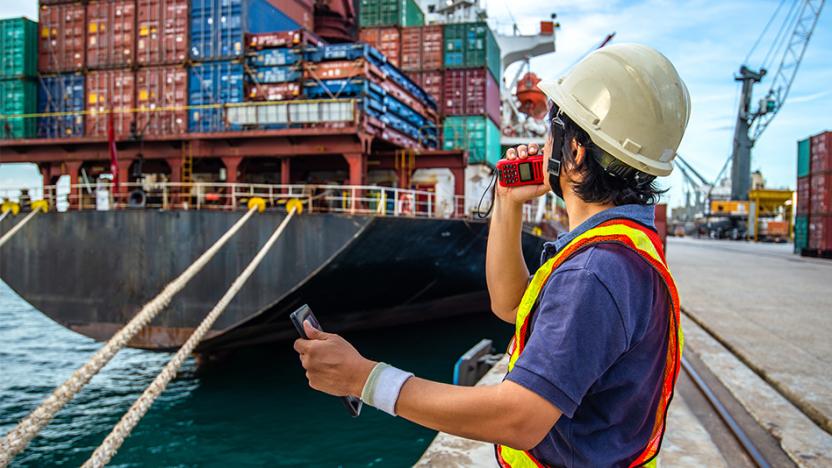 Container ship and man holding walkie talkie